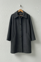 Cappotto grigio scuro bottoni metallici su gruccia