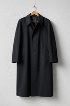 Cappotto grigio scuro minimalista su gruccia