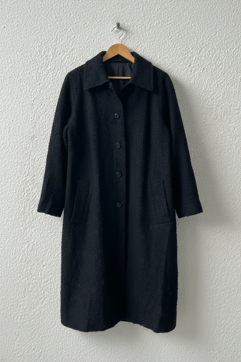 Cappotto nero bouclé su gruccia