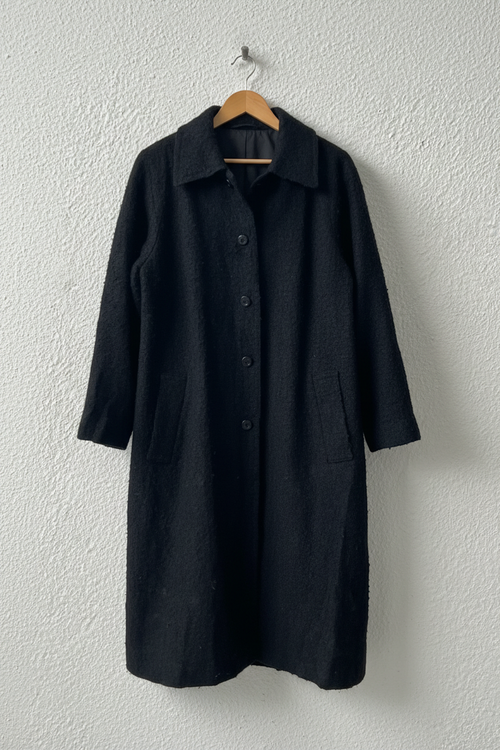 Cappotto nero bouclé su gruccia