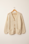 Cardigan crochet su gruccia sfondo neutro