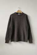 Maglione grigio melange su gruccia sfondo neutro