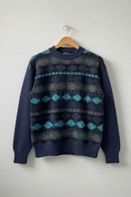 Maglione navy geometrico su gruccia sfondo neutro